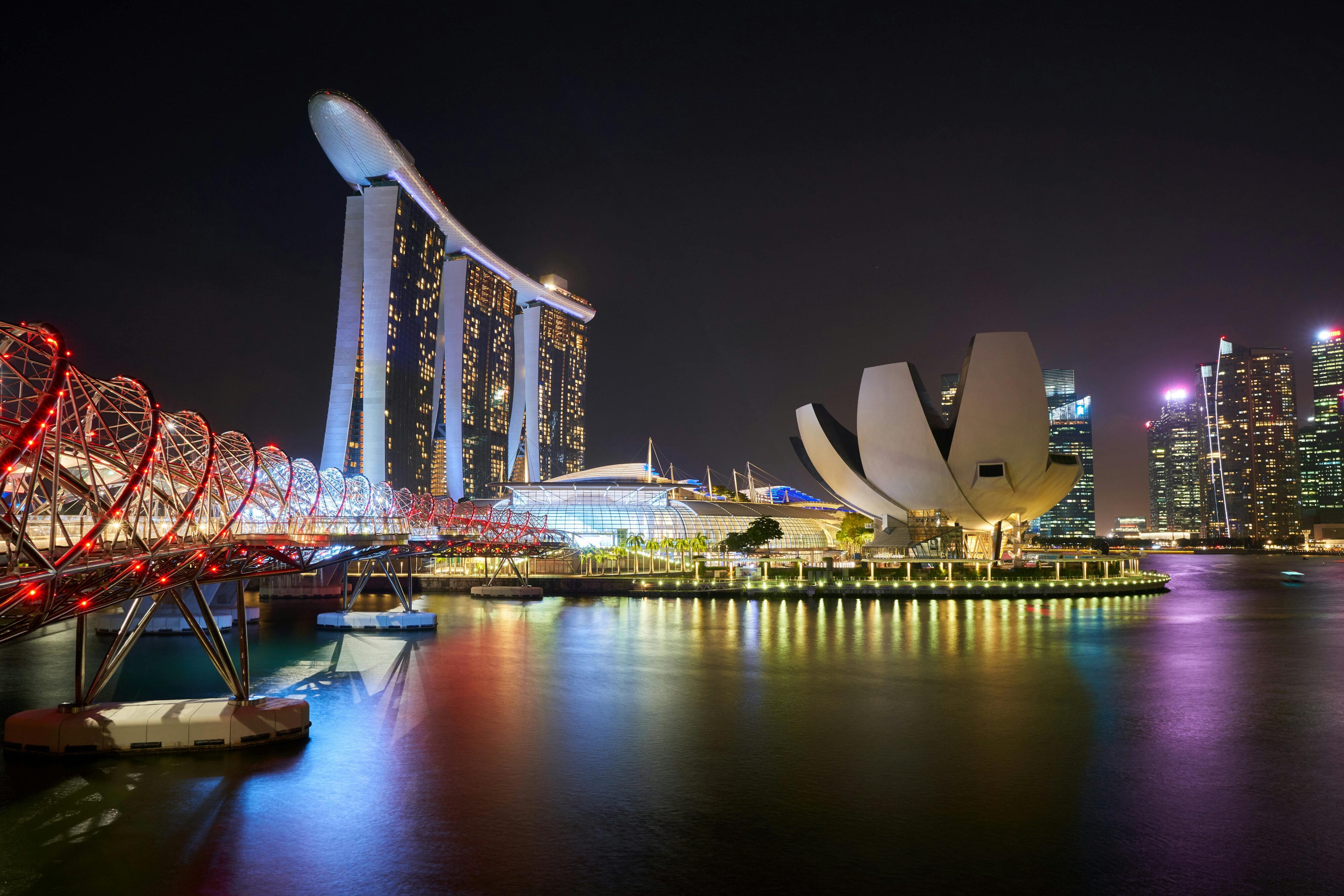 Stunning night view of Marina Bay Sands and Helix Bridge illuminated over water in Singapore. This is a success story of psychological contrast