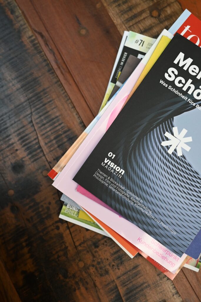 a stack of magazines sitting on top of a wooden table. They cover sustainability themes like agroforestry economy, esg economy, climate-action innovation, climate-change, agriculture, circular economy